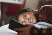 Sonriente, muchacha adolescente feliz usando teléfono inteligente - foto de stock