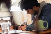 Сосредоточенный молодой студент колледжа учится в кафе — стоковое фото