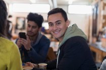 Portrait confident young man hanging out with friends in cafe — Stock Photo