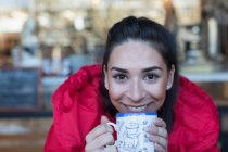 Gros plan portrait heureuse jeune femme buvant du café — Photo de stock