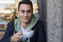 Porträt selbstbewusster junger Mann trinkt Cappuccino — Stockfoto