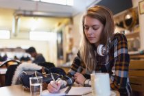 Young female college student studying in cafe — Stock Photo