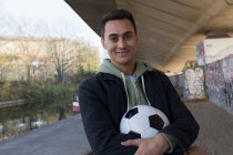 Porträt selbstbewusster junger Mann mit Fußball — Stockfoto