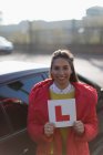 Porträt: Glückliche junge Frau mit Führerschein neben Auto — Stockfoto