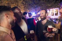 Happy male friends drinking beer at garden party — Stock Photo
