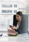 Businesswoman using smart phone in conference room — Stock Photo
