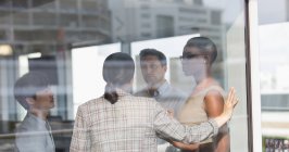 Business people talking at sunny urban office window — Stock Photo