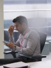 Бизнесмен, использующий смартфон в офисе — стоковое фото