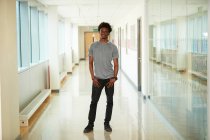 Портрет уверенного студента колледжа в коридоре — стоковое фото