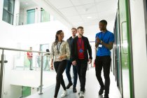 College students walking and talking in corridor — Stock Photo