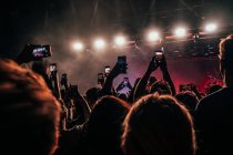 Толпа со смартфонами, снимающими музыкальный концерт — стоковое фото