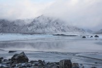 Montagna innevata maestosa dietro l'oceano Skagsanden Lofoten Norvegia — Foto stock