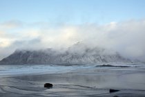 Clouds over snow covered mountain ocean Skagsanden Lofoten Norway — Stock Photo