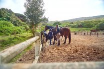 Жінка-інструктор навчає верхи на коні дівчині в сільській місцевості — стокове фото