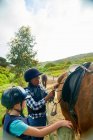 Girls adjusting stirrups for horseback riding — Stock Photo