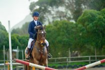 Teenage girl equestrian jumping — Stock Photo