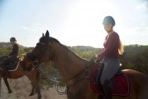 Ritratto felice giovane donna a cavallo sulla spiaggia soleggiata — Foto stock
