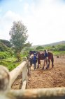 Female instructor teaching horseback riding to girl in sunny paddock — Stock Photo