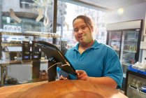 Mujer joven con síndrome de Down que trabaja en la cafetería - foto de stock