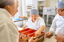 Koch und Studenten mit Down-Syndrom backen Brot in der Küche — Stockfoto