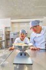 Étudiants atteints du syndrome de Down mesurant la pâte dans la cuisine — Photo de stock
