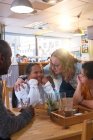 Mentor e mulheres jovens com Síndrome de Down conversando no café — Fotografia de Stock