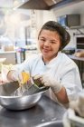 Portrait happy young woman with Down Syndrome working kitchen — Stock Photo