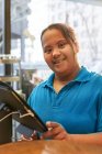 Портрет уверенной молодой женщины с синдромом Дауна, работающей в кафе — стоковое фото