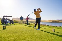 Männlicher Golfer beim Abschlag an der sonnigen Golf-Abschlagbox — Stockfoto
