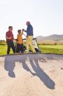 Golfisti maschili che celebrano dietro bunker di golf soleggiato — Foto stock