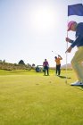 Golfista masculino colocando em direção buraco no campo de golfe ensolarado colocando verde — Fotografia de Stock