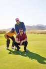 Чоловічі гольфи планують застрелити на сонячному полі для гольфу, додаючи зелений — стокове фото