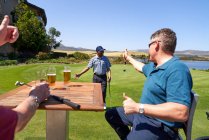 Golfer trinken Bier und jubeln Freund beim Putten zu — Stockfoto