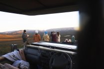 Groupe Safari regardant la vue sur le paysage à l'extérieur du véhicule hors route — Photo de stock