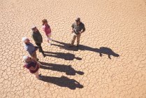 Safari guida turistica parlando con il gruppo sulla soleggiata terra incrinata — Foto stock