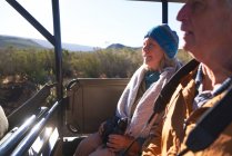 Happy senior couple riding in off-road safari vehicle — Stock Photo