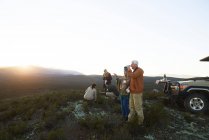 Safari grupo de viaje beber té y disfrutar de la vista del paisaje amanecer - foto de stock