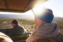 Happy senior woman riding in sunny safari off-road vehicle — Stock Photo