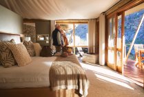 Glückliches Senioren-Paar bei der Ankunft im sonnigen Safari-Lodge-Hotelzimmer — Stockfoto