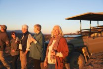 Unbekümmerte Seniorin auf Safari trinkt Champagner bei Sonnenuntergang — Stockfoto