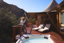 Affectionate senior couple on sunny luxury safari lodge balcony — Stock Photo