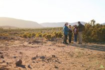 Safari tour guide talking with group in sunny grassland South Africa — Stock Photo
