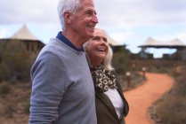 Happy senior couple on footpath outside safari lodge — Stock Photo