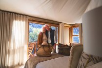 Ritratto felice coppia anziana che si abbraccia nella camera da letto dell'hotel — Foto stock