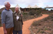 Glückliches Seniorenpaar auf Fußweg vor Safari-Lodge — Stockfoto