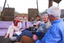 Amici anziani che bevono vino sul patio dell'hotel — Foto stock