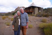 Portrait happy senior couple outside safari cabin — Stock Photo