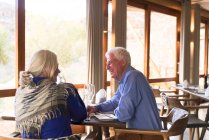 Счастливая пожилая пара обедает в ресторане — стоковое фото