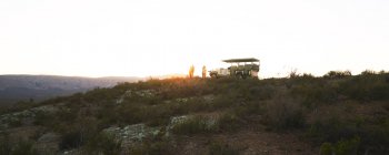 Safari tour group e veículo off-road na colina ao nascer do sol África do Sul — Fotografia de Stock