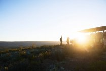 Safari-Reisegruppe auf sonnigem Hügel bei Sonnenaufgang Südafrika — Stockfoto